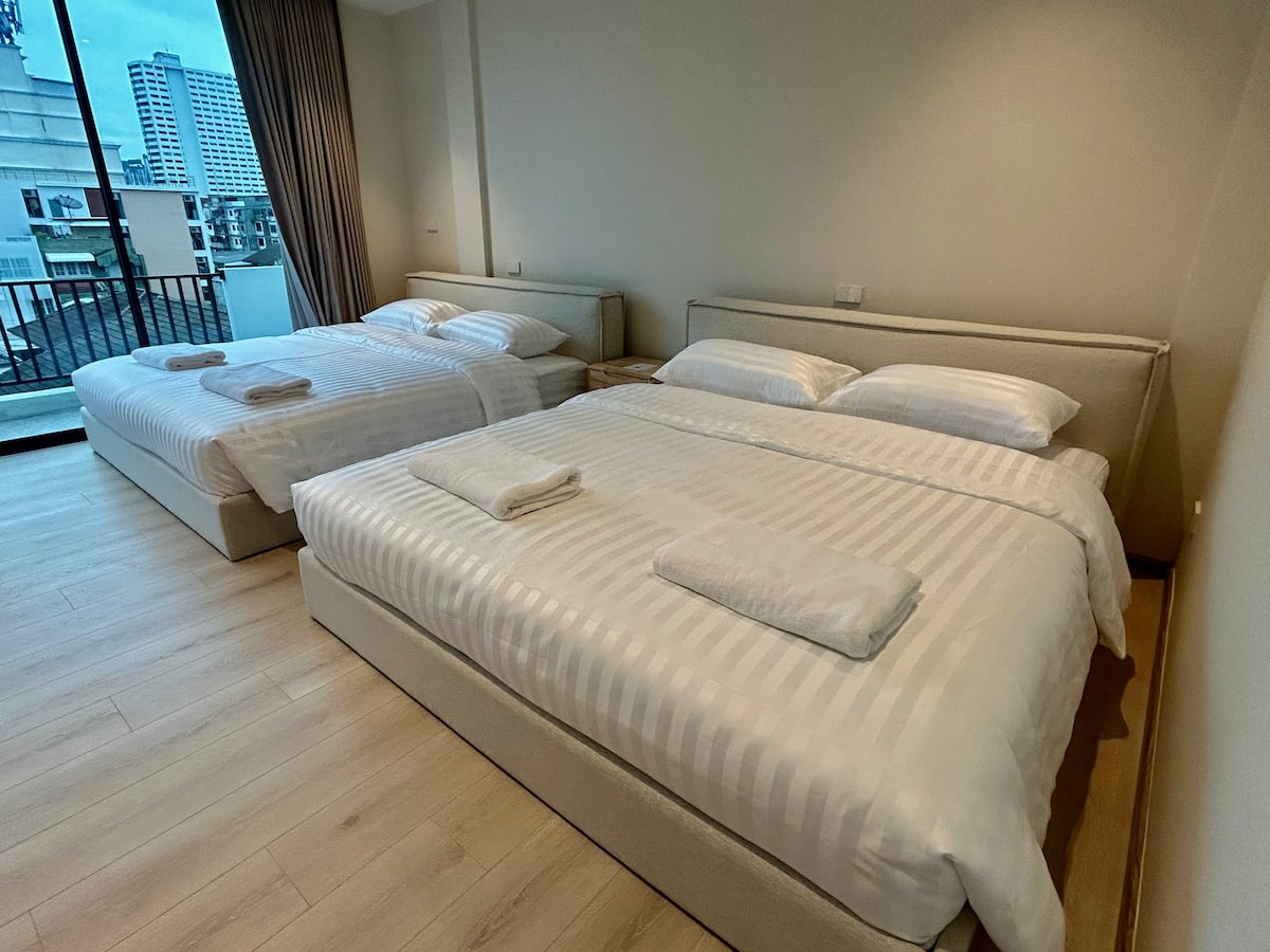 Bedroom with two king beds at the Huai Khwang luxury house